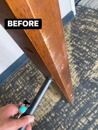 a person is using a tool to clean a wooden table