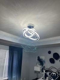 a blue and white bedroom with a ceiling light