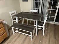 a kitchen table with four chairs and a bench