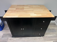 a black kitchen cart with a wooden top