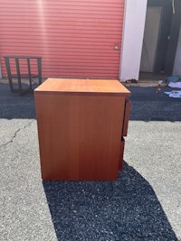 a small wooden desk sitting in a parking lot