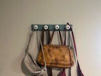 a coat rack with several purses hanging on it