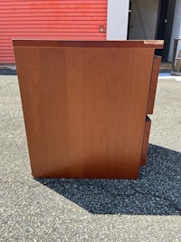 a brown wooden desk sitting on a parking lot