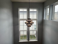 a chandelier hanging above a window in a home