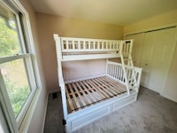 a white bunk bed in a room with a window