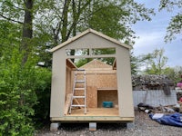 a small shed is being built in a backyard