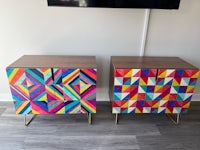 two colorful side tables with geometric designs on them